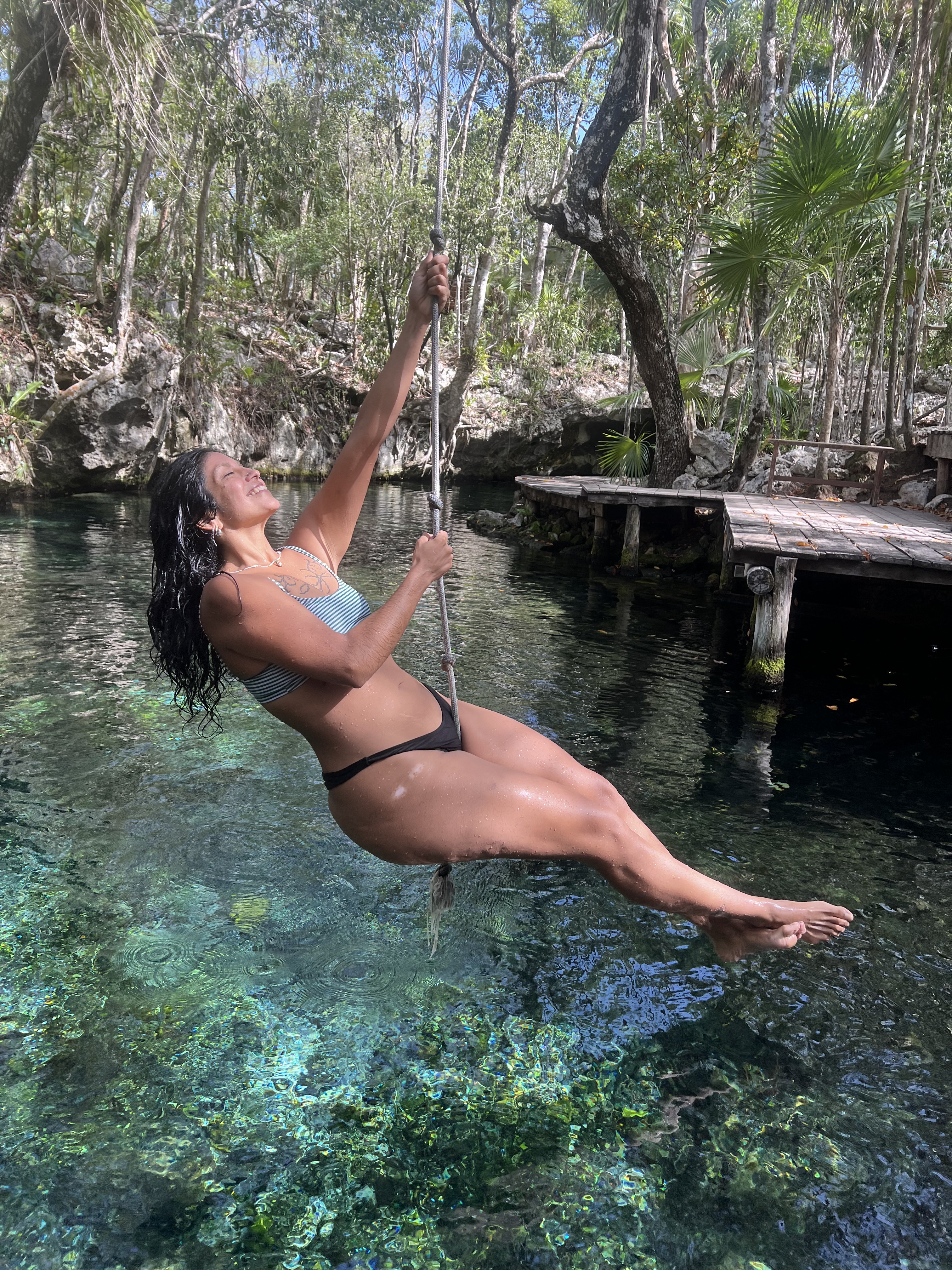 Swinging out over a cenote on a Camp Queerness trip in Tulum