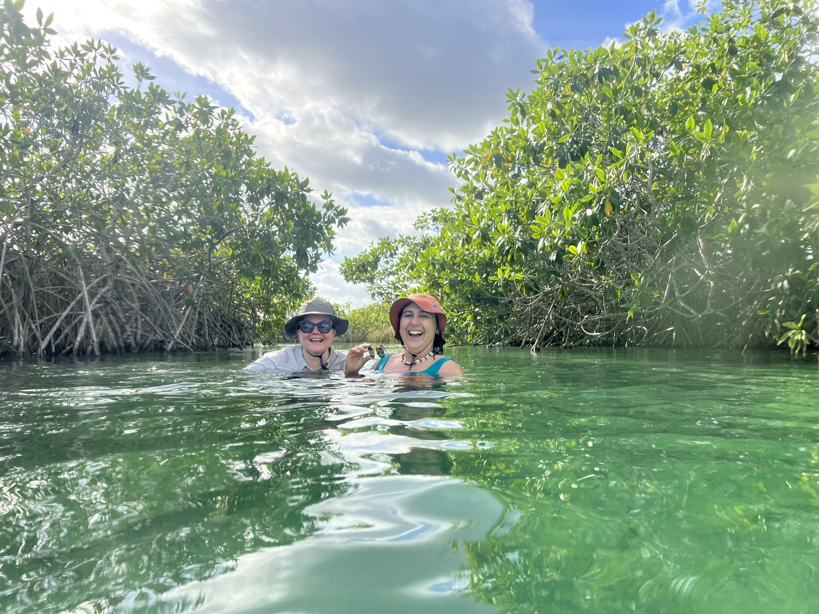 Friends swimming through the mangroves in Tulum