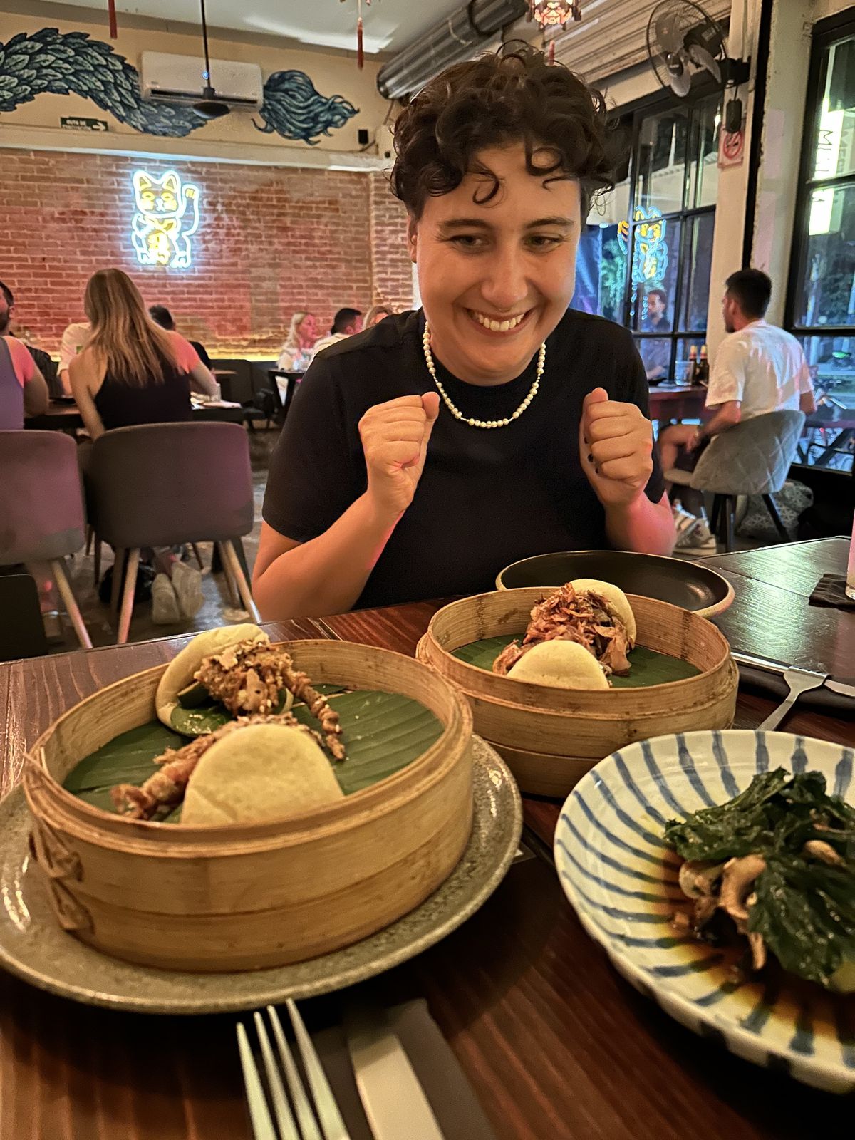 A friend celebrating over bao buns at a Tulum restaurant on the Food Tour