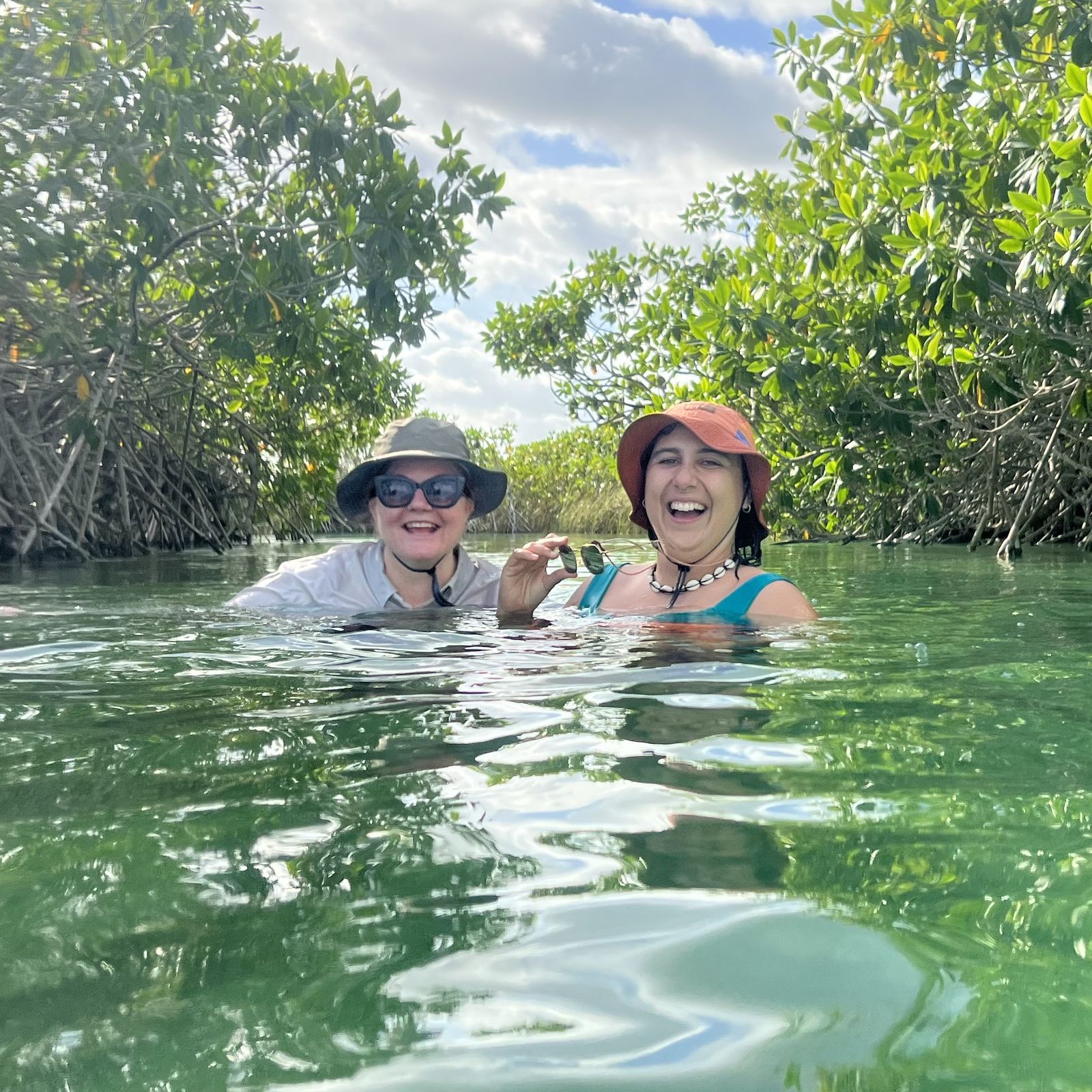 Friends swimming through the mangroves in Tulum