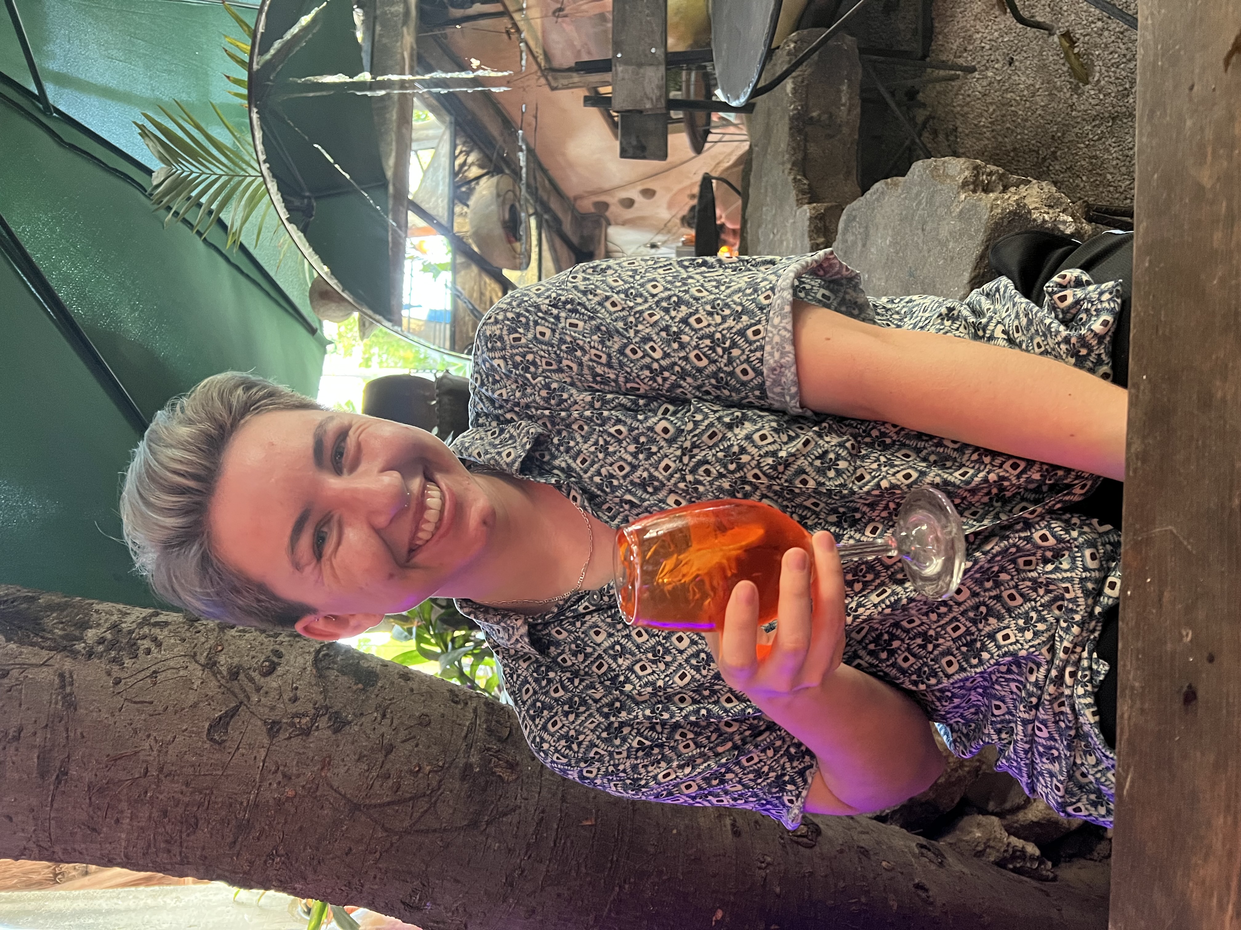 Santi smiling with a drink at a cafe in Tulum