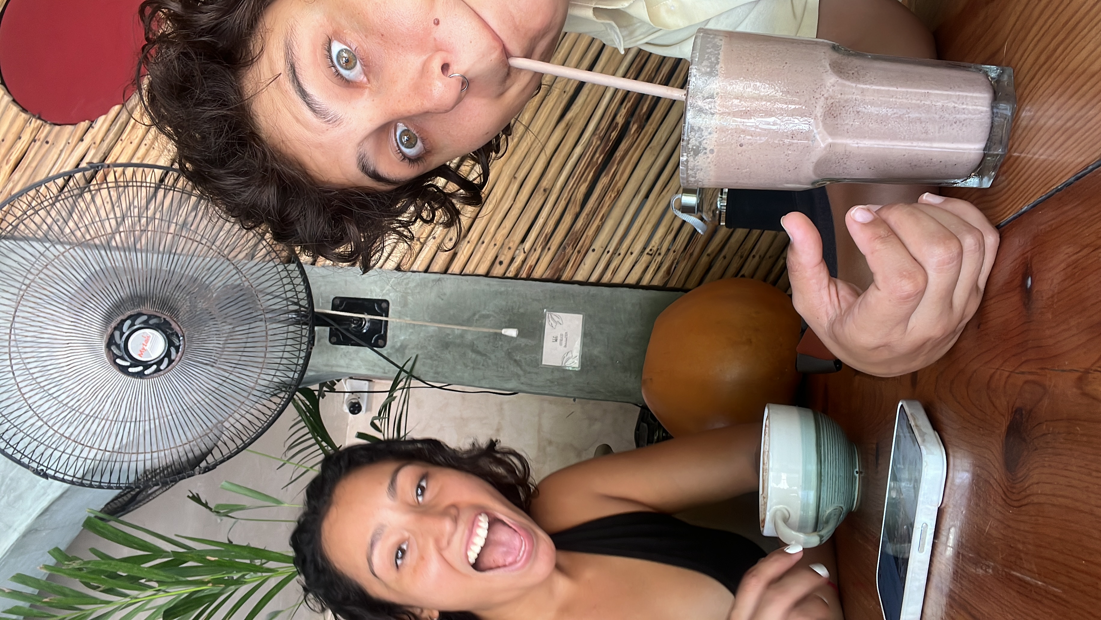 Santi holding an iced coffee at Story Horse cafe in Tulum