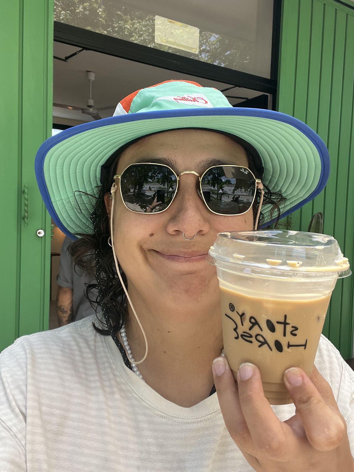 Santi holding an iced coffee from Story Horse cafe in Tulum