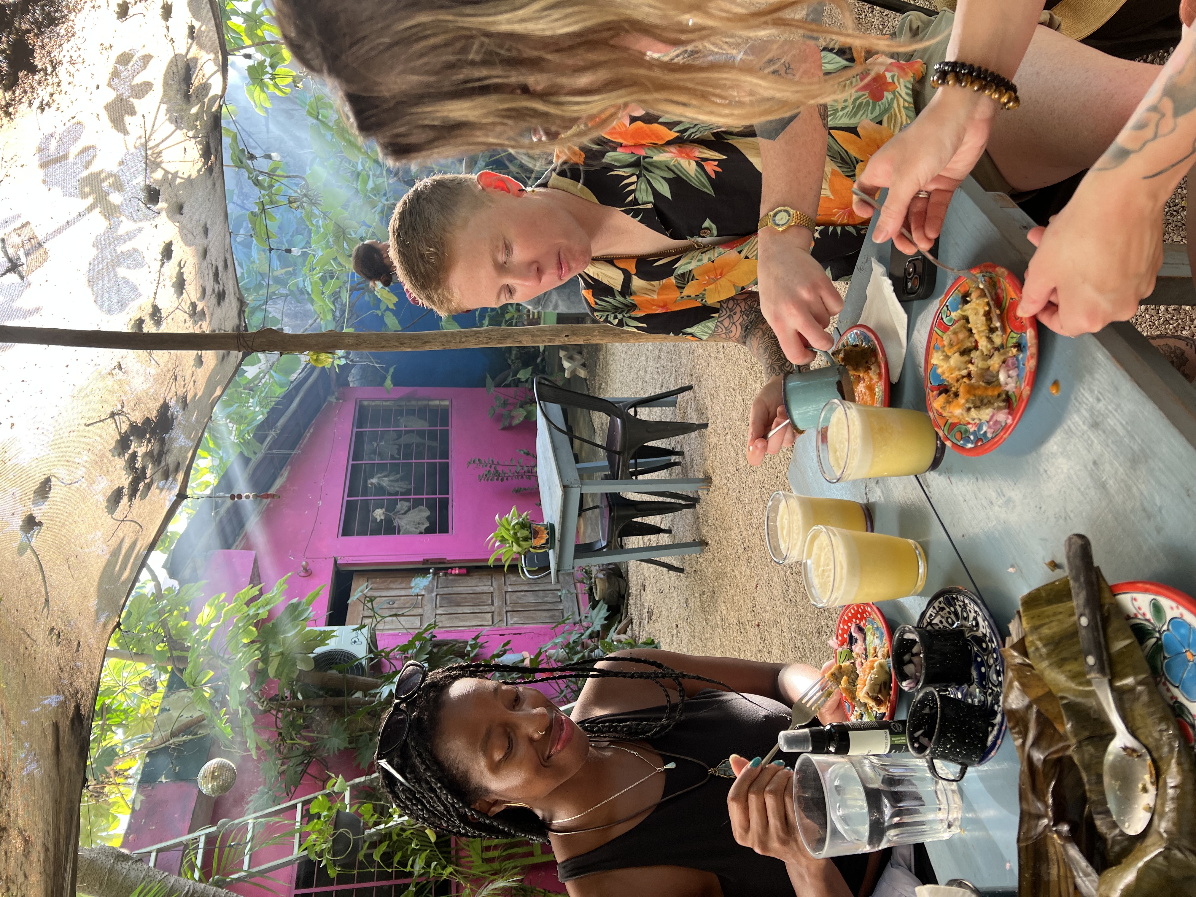 Friends sharing coffee and food together at a cafe table in Tulum